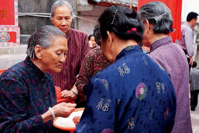 黃福娣把祭神的米派給村民，祈愿神明保佑